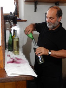 Pouring some wine into a bottle for another customer.